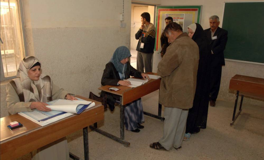 Citizens of Iraq gather to vote at a school